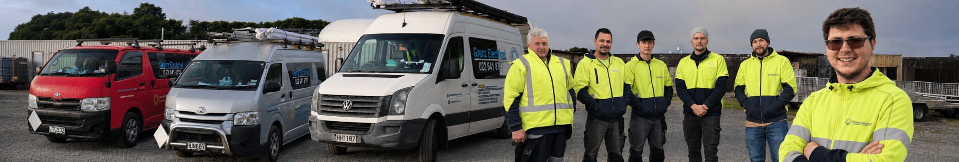 The Grenz Electrical team standing with the company service vehicles